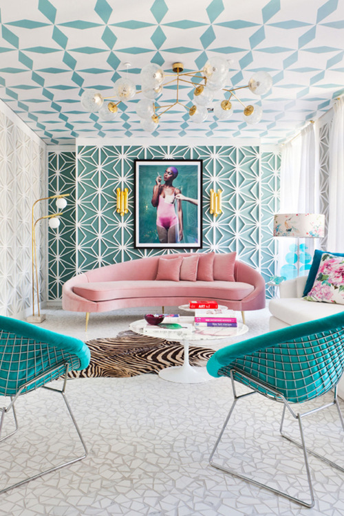 Art Deco style interior with eleborately patterned ceiling, gold lighting and plush pink velvet sofa