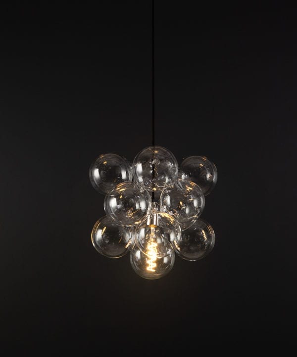 glass bubble light chandelier with 12 clear glass baubles and 1 silver bulb holder suspended from black fabric cable against a black wall