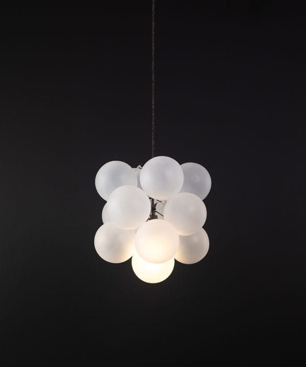 frosted glass bubble chandelier with 12 glass orbs and 1 bronze bulb holder suspended from textured cable against a black wall