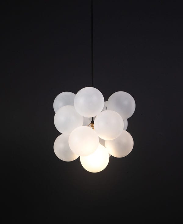 frosted glass bubble chandelier with 12 glass orbs and 1 gold bulb holder suspended from black cable against a black wall