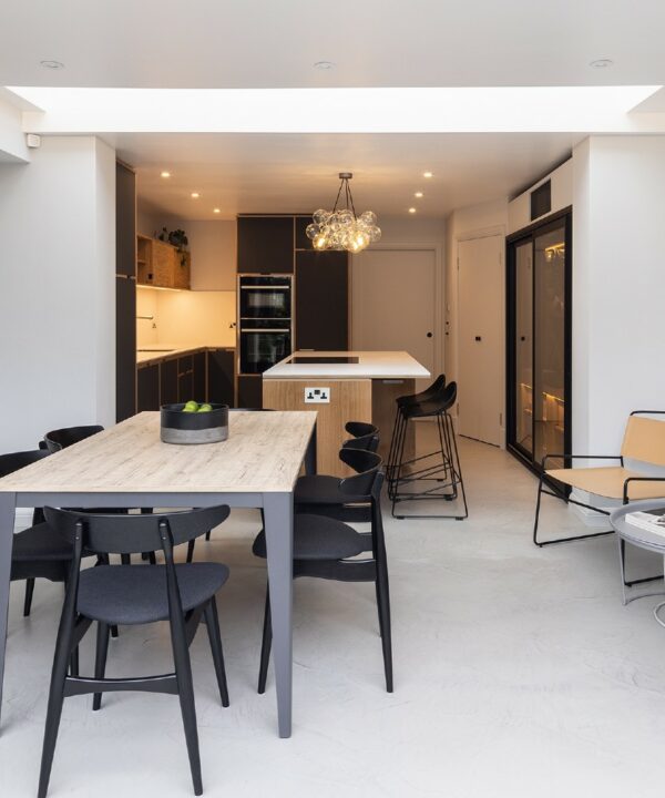 medium clear bubble chandelier suspended above an induction hob on a wooden and white kitchen island in a kitchen diner
