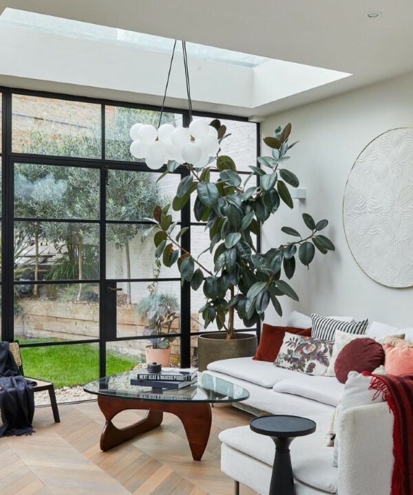 medium frosted bubble chandelier suspended above a glass and wooden coffee table in a white living room