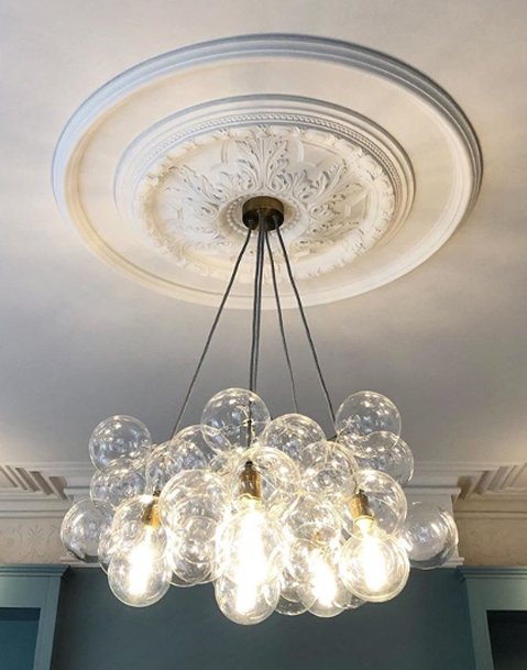 clear bubble chandelier suspended in a blue and white living room