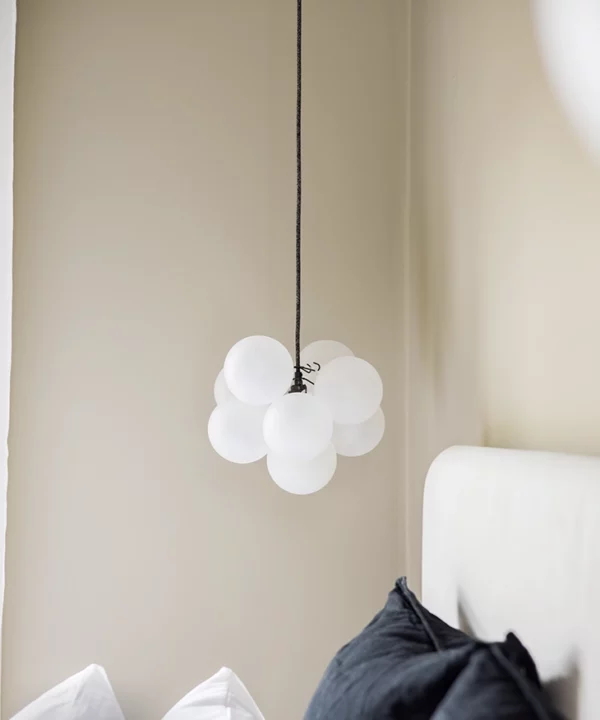 Small frosted bubble chandelier over bedside.