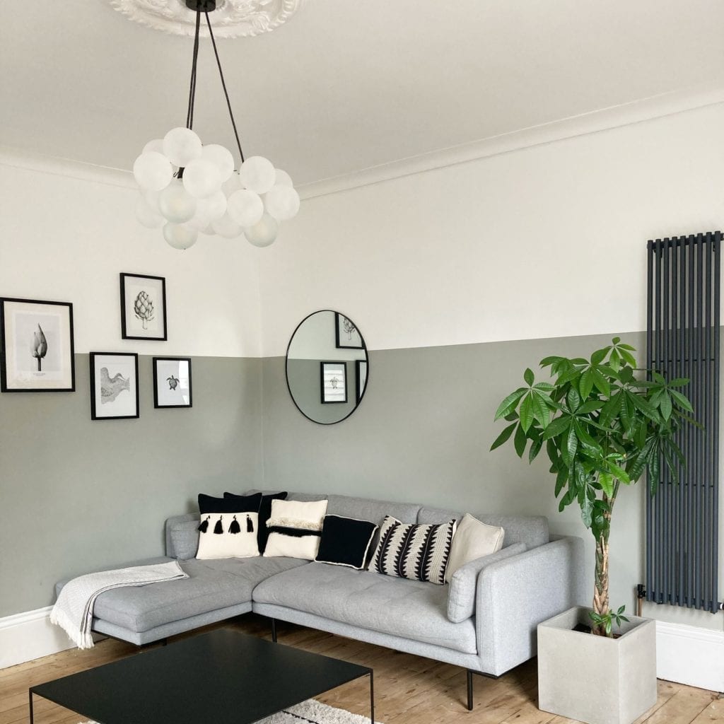 medium frosted bubble chandelier suspended from a white ceiling above a grey sofa