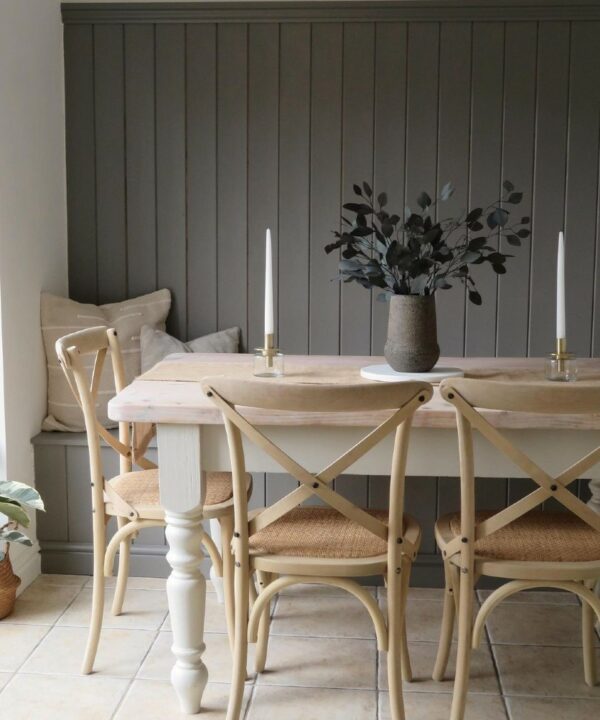 bunch of eucalyptus populus in a stone vase in the centre of a wooden table in a grey panelled dining room