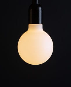 g95 aurora opal light bulb lit against black background