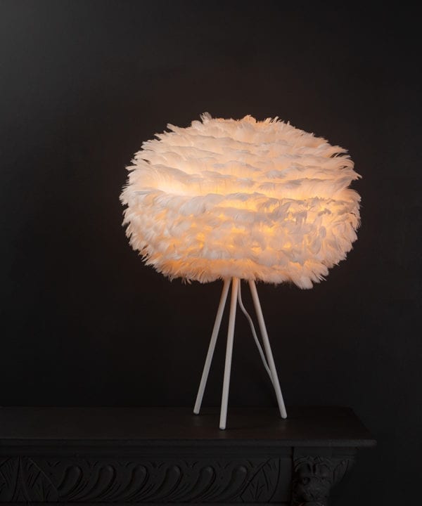 Umage white table lamp shade with feather shade on white metal tripod base against black background