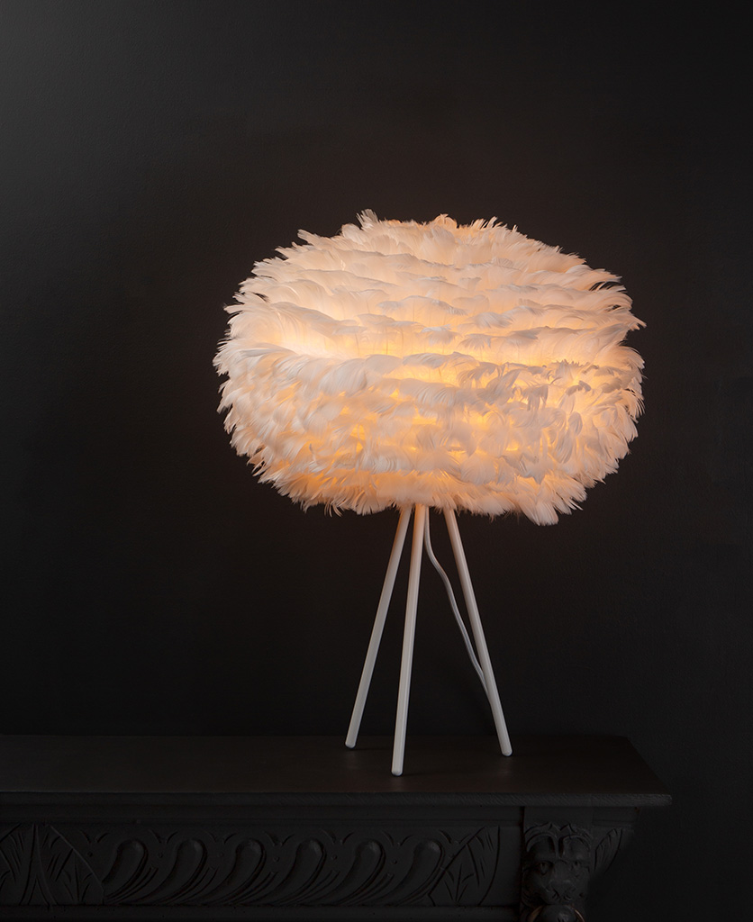 Umage white table lamp shade with feather shade on white metal tripod base against black background