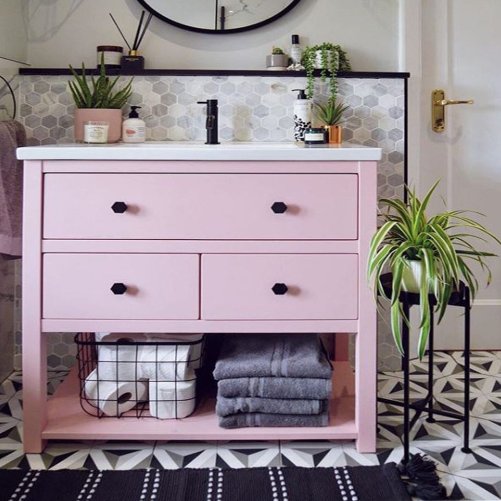 pink undersink storage with Bauhaus black drawer knobs in a monochrome bathroom