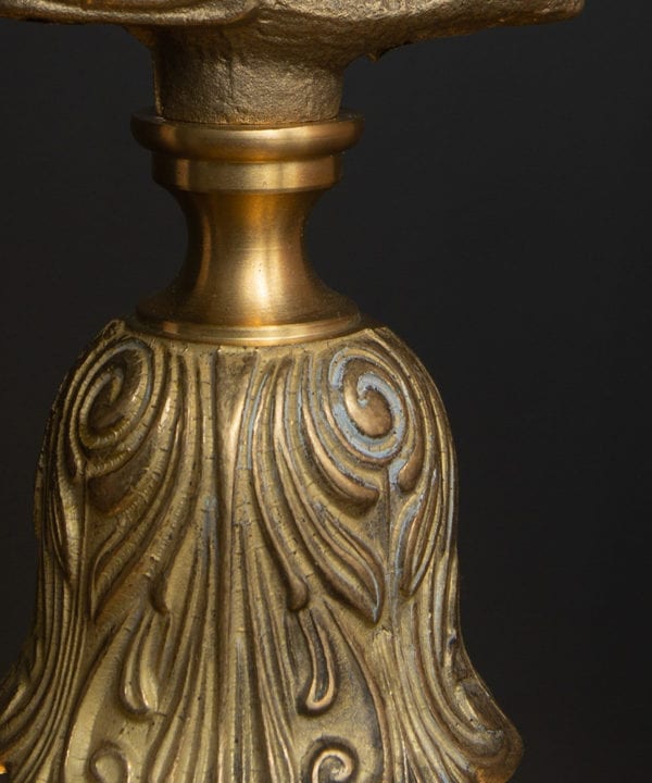 closeup of solid brass bulb holder with intricate pattern against black background