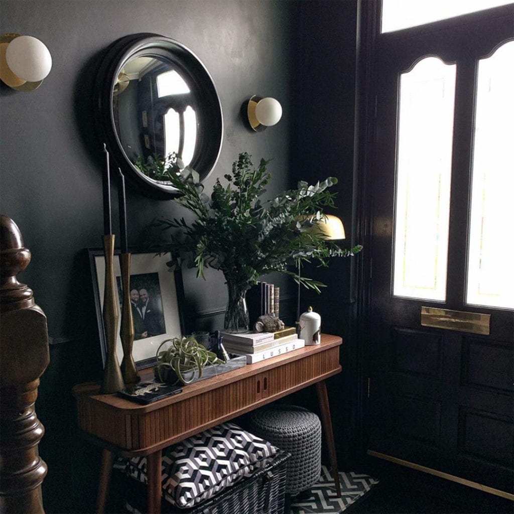 preserved eucalyptus in a glass vase in a black painted hallway