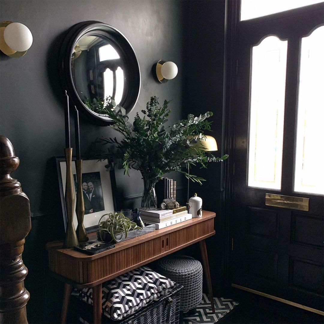 preserved eucalyptus in a glass vase in a black painted hallway