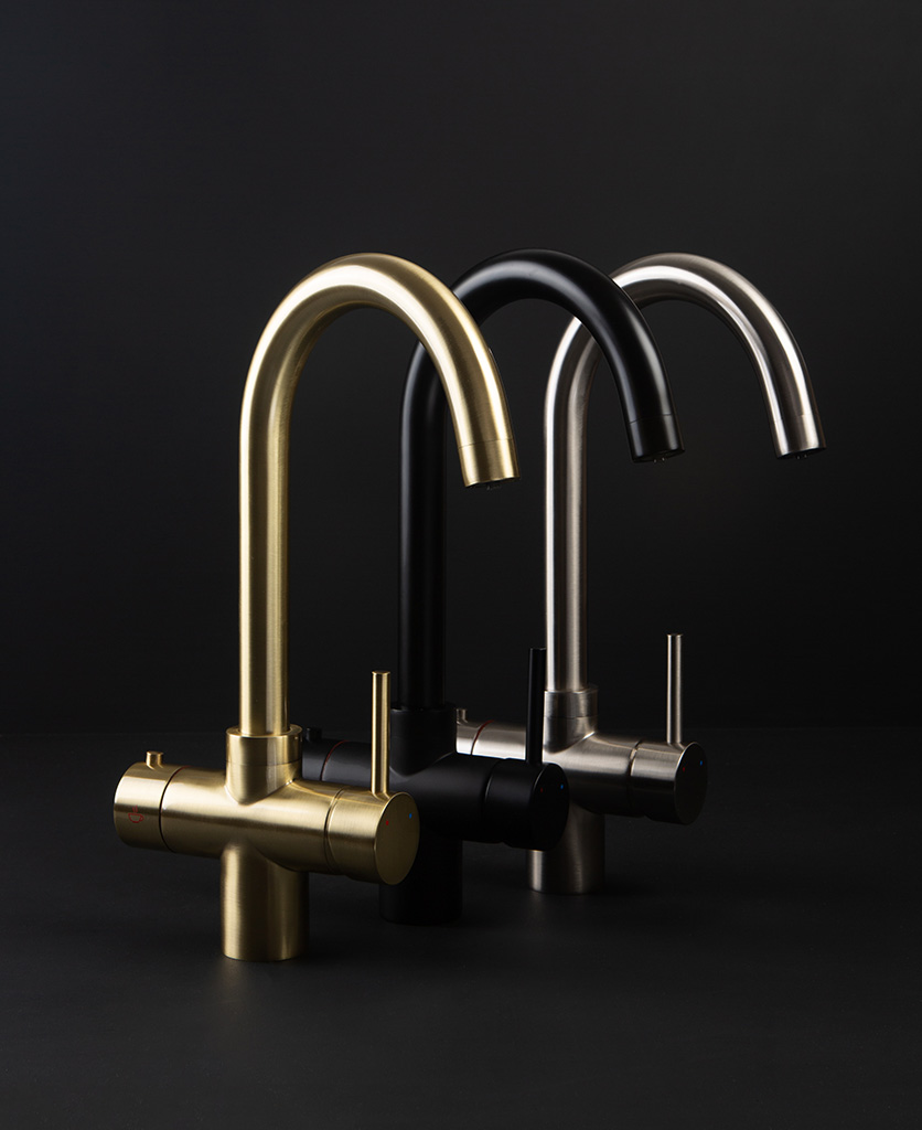 Black gold and silver hot water taps on a black background