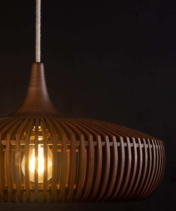 close up of wooden light shade with linen cable against black background