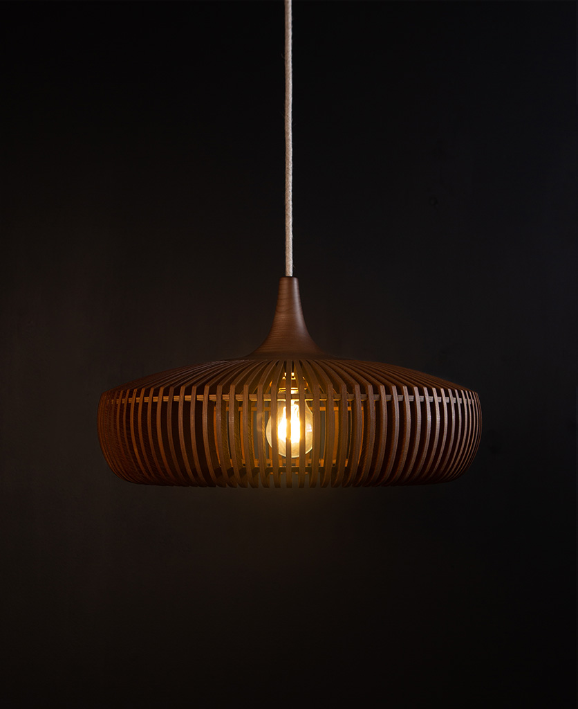 wooden light shade with linen cable against black background