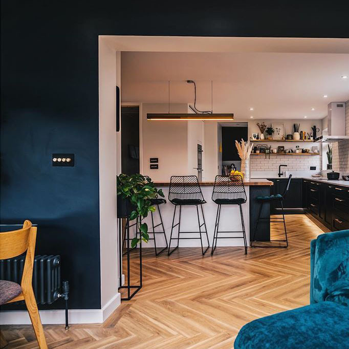 navy and soft pink open plan living-kitchen with wooden floor