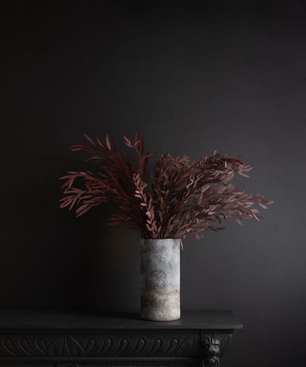 rock effect vase with preserved red nicholii against black background