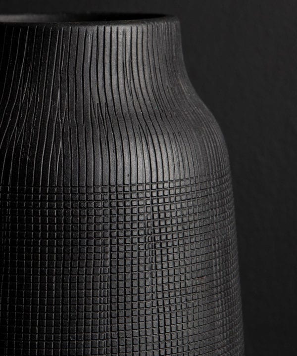 close up of black vase against black background