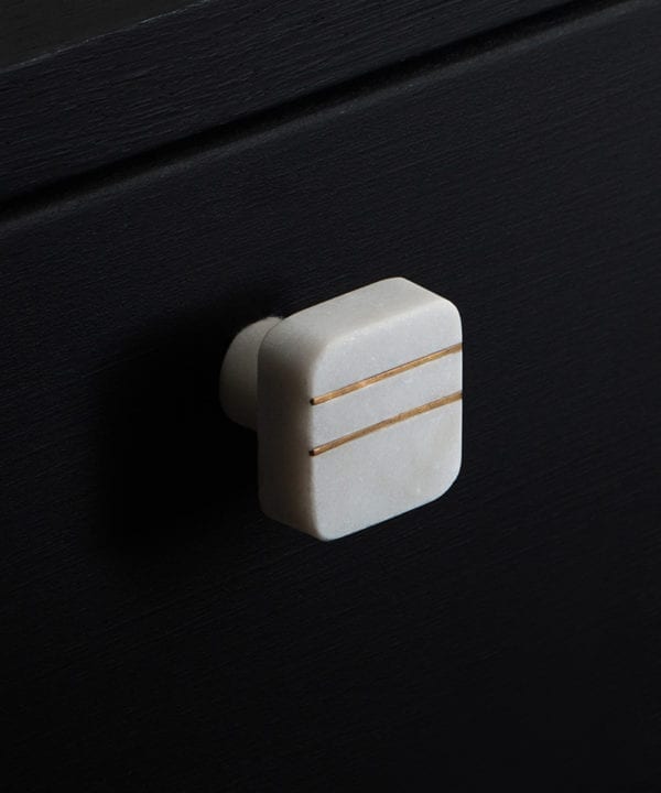talenti white square marble knob with two gold stripes on a black drawer