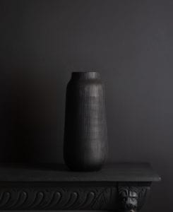 black tall vase against black background