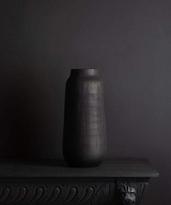 black tall vase against black background