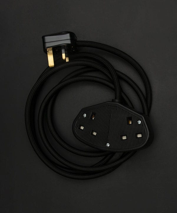 black fabric extension cable with black double socket and black plug against black background