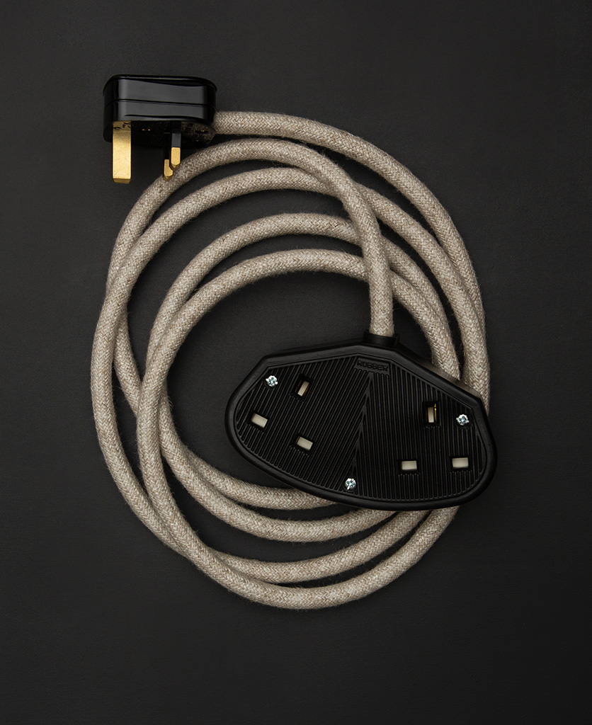 5m cream course linen fabric extension cable with double black socket and plug against black background