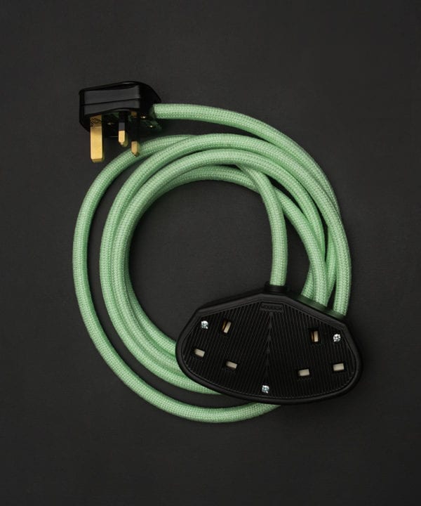 neo mint fabric extension cable with black plug and double socket against black background