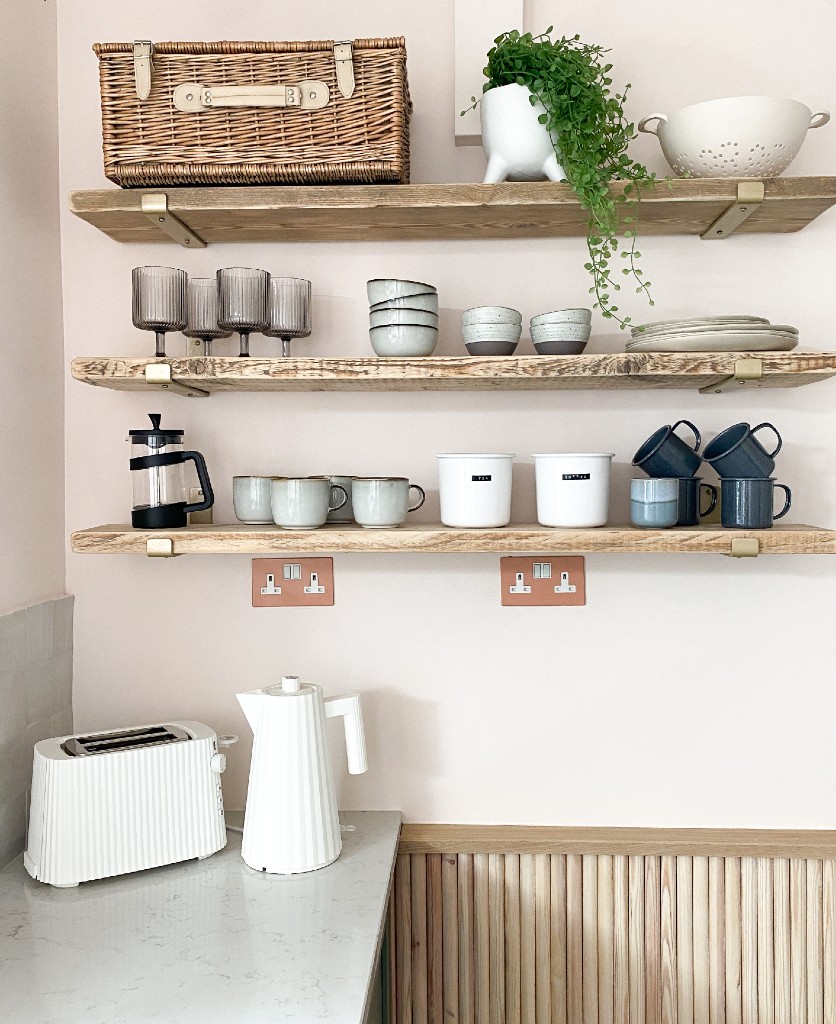 calming colours cinnamon and white double sockets installed beneath wooden open shelving in a kitchen