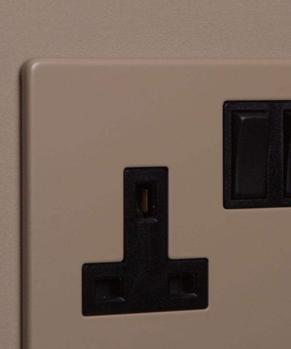 close up of caramel latte double plug socket with black insert on caramel latte background