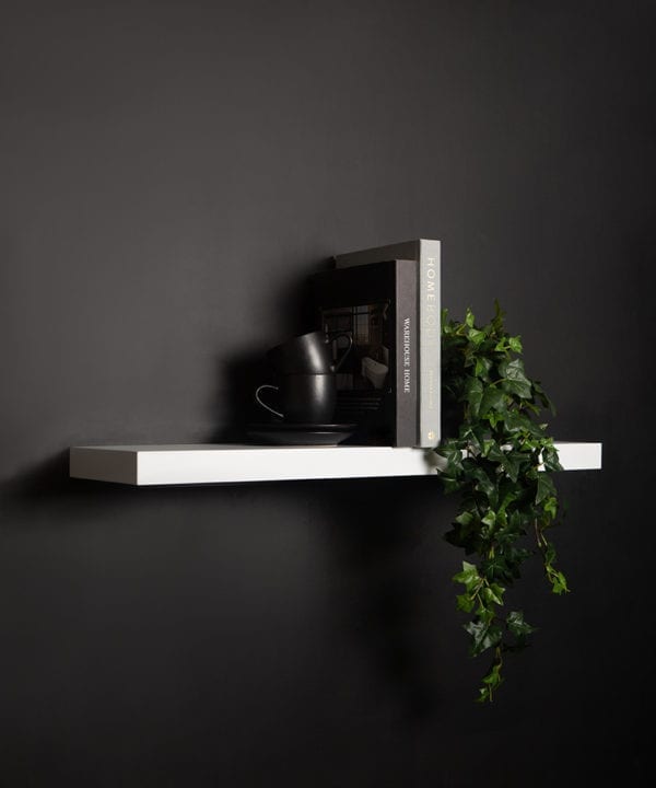 large white floating shelf on black background