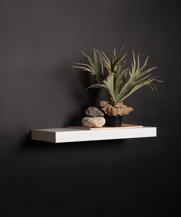 medium white floating shelf on black background