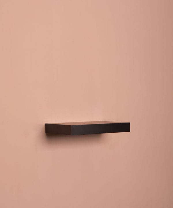 small black floating shelf on pink background