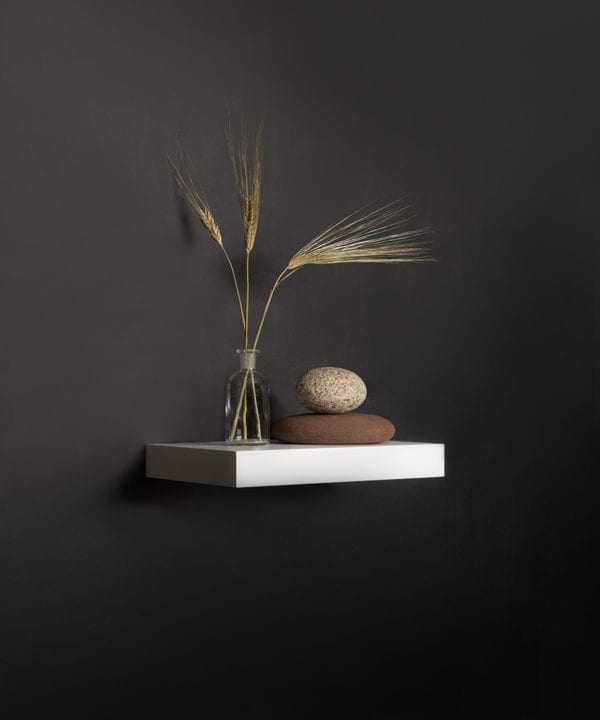 small white floating shelf on black background