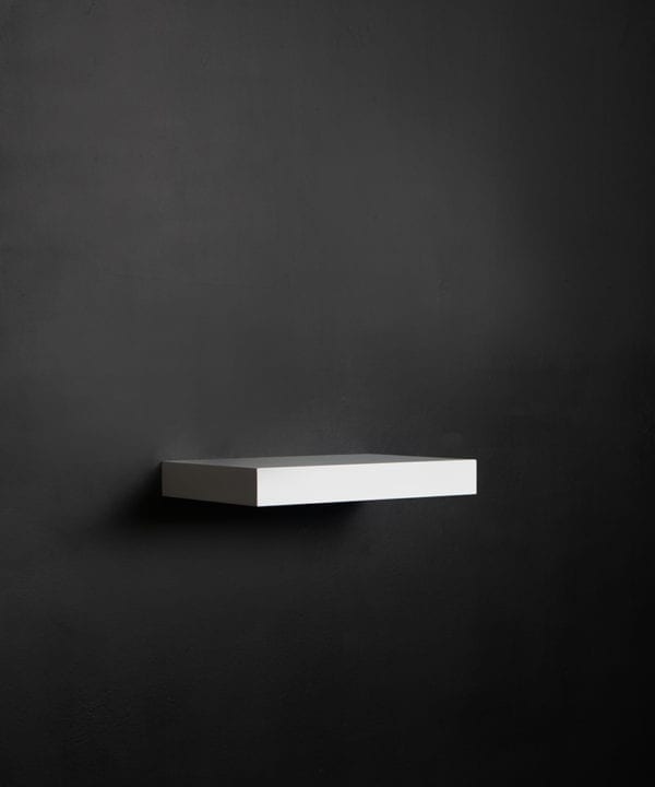 small white floating shelf on black background