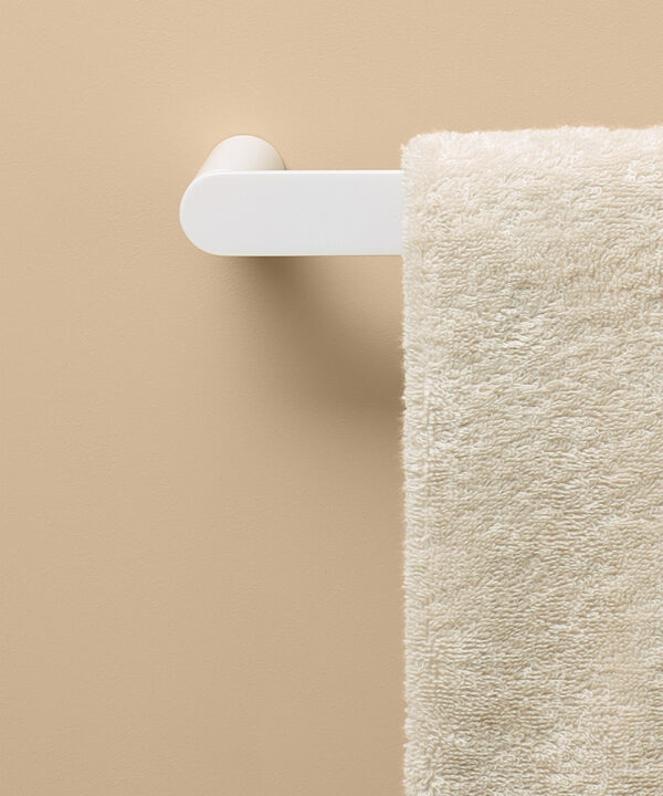 white hand towel rail on peach background