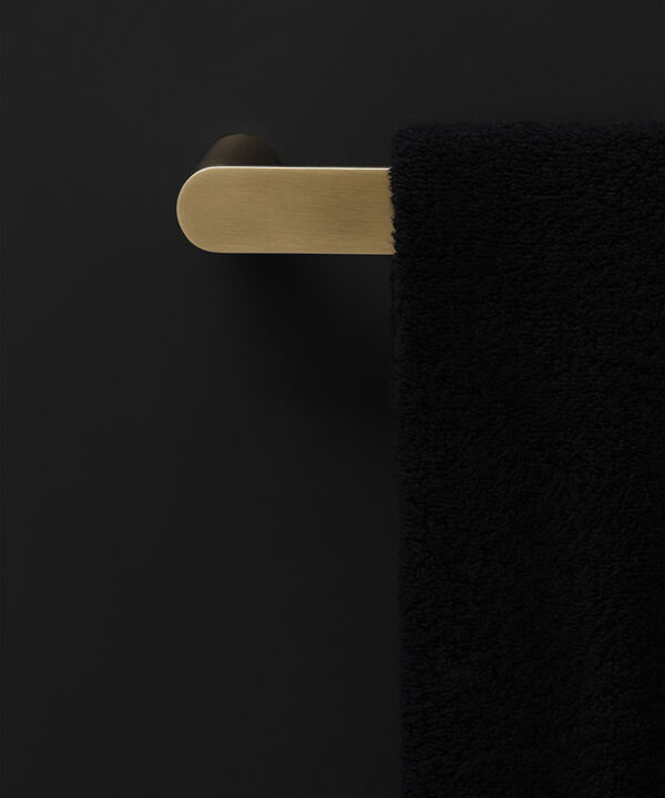 gold hand towel rail on black background