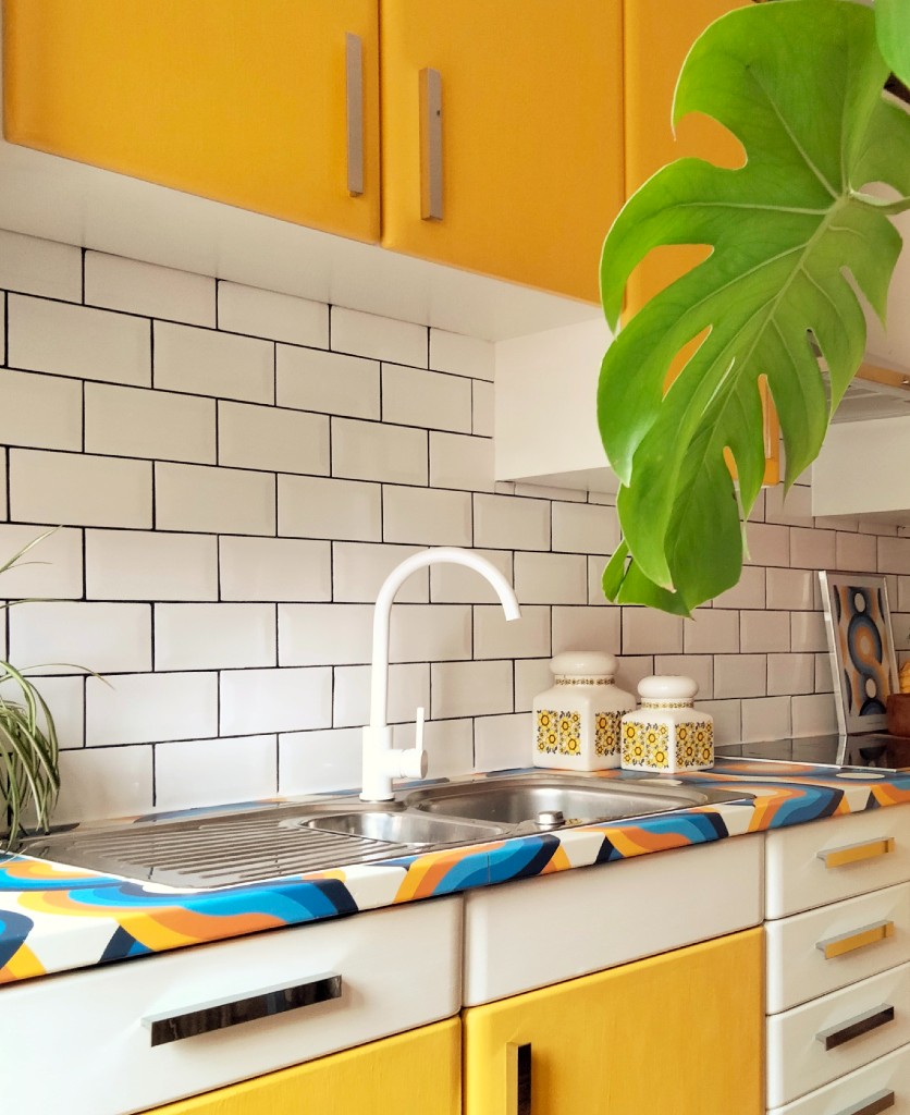 white tinkisso kitchen tap in a 70's inspired yellow and white kitchen