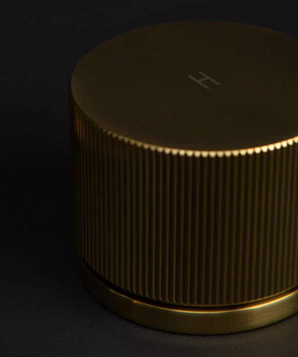 gold reeded tap close up of hot handle on black background