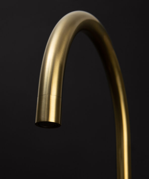 gold reeded tap close up of spout on black background