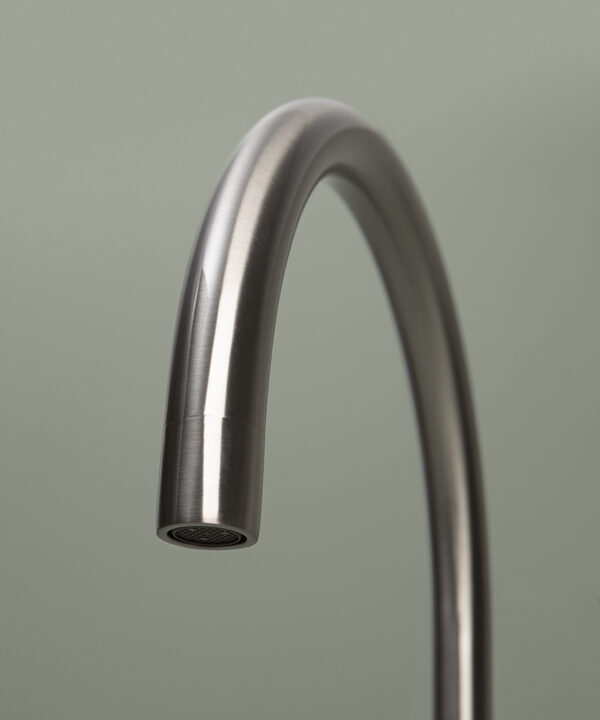 silver reeded tap close up of spout on grey background