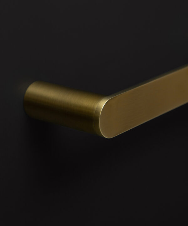 close up of gold towel rail on black background