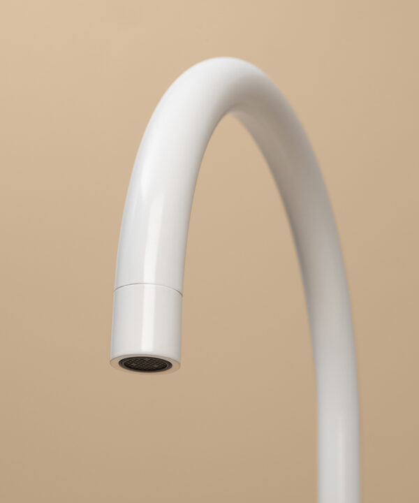 white reeded tap close up of spout on peach background