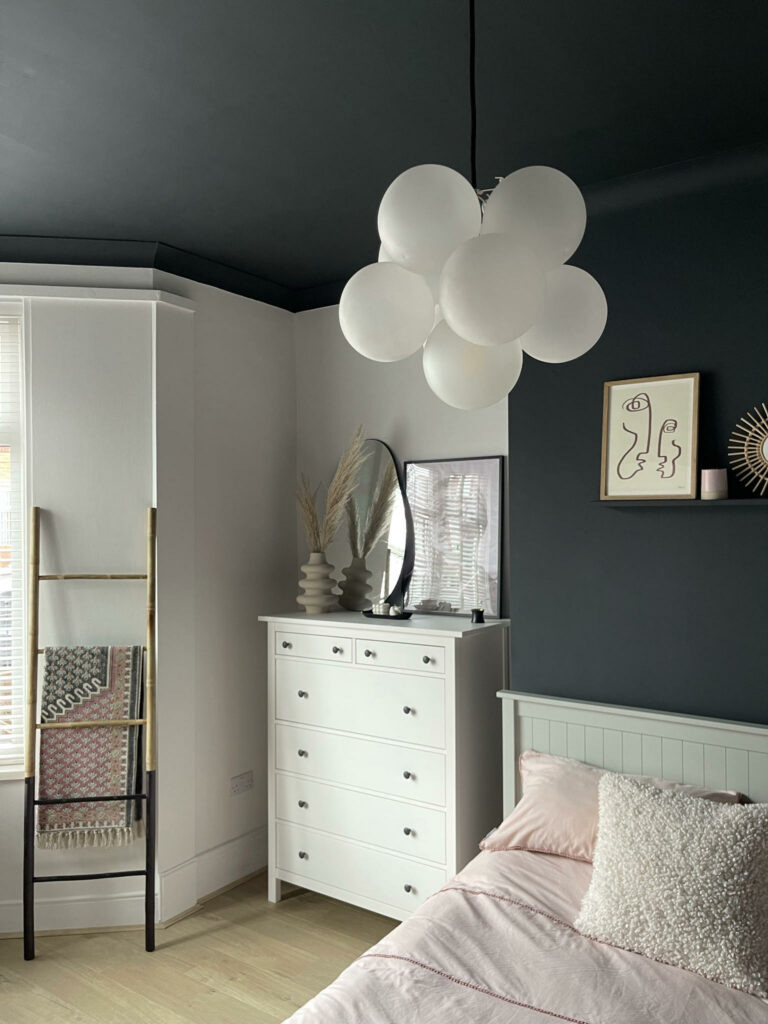 one point frosted bubble pendant light chandelier suspended above a bed in a monochrome bedroom