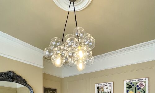 clear three point bubble chandlier in living room of Victorian home