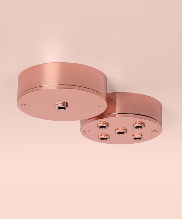 polished copper ceiling roses group shot on pink background