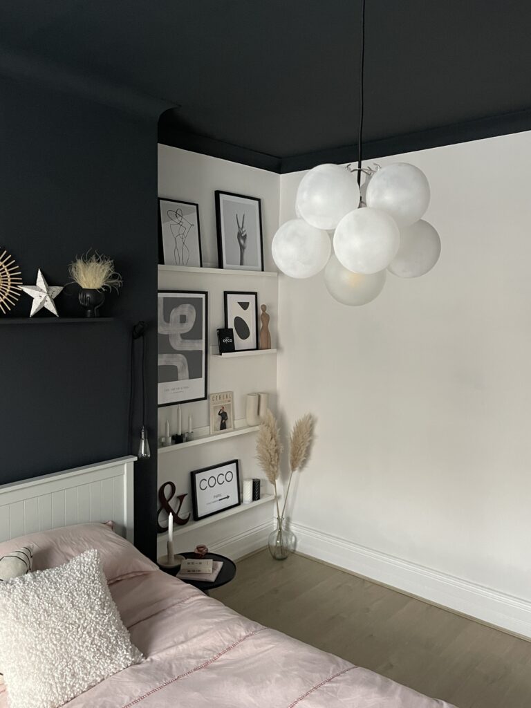 one point frosted bubble chandelier suspended in a monochrome bedroom