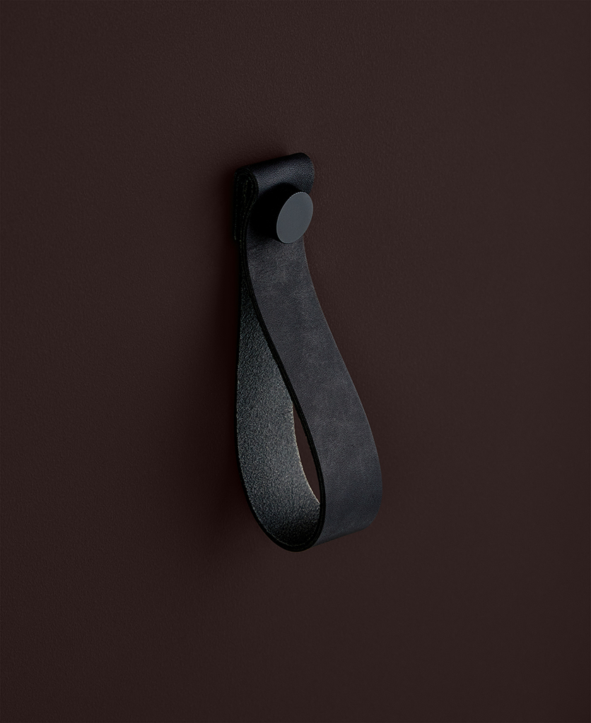 large black magni handle with black stud against chocolate brown background