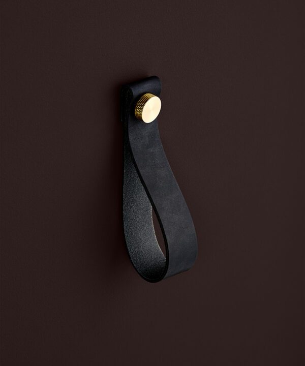 large black magni handle with gold stud against chocolate brown background